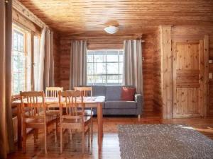 a dining room with a table and chairs and a couch at Holiday Home Marttalanmäki by Interhome in Valittula