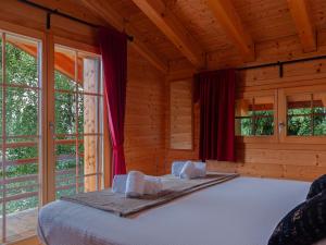 een slaapkamer met een bed in een houten kamer bij Chalet Mimique by Interhome in Nendaz