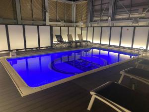 a large swimming pool with blue water in a building at APA Hotel & Resort Nishishinjuku-Gochome-Eki Tower in Tokyo