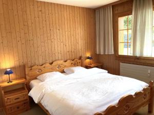 ein Schlafzimmer mit einem großen Bett mit weißer Bettwäsche in der Unterkunft Apartment Colline 3 by Interhome in Champex