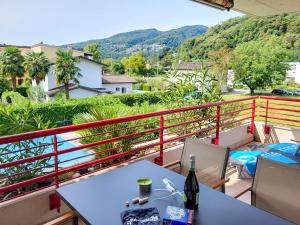 einen Balkon mit einem Tisch und einer Flasche Wein in der Unterkunft Apartment Caslago-1 by Interhome in Caslano