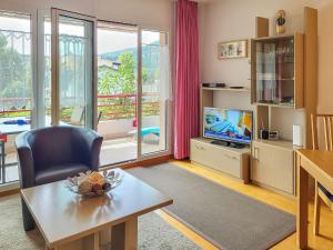ein Wohnzimmer mit einem Tisch und einem TV in der Unterkunft Apartment Caslago-1 by Interhome in Caslano