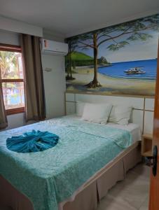 um quarto com uma cama com um quadro na parede em Village Taperapuan em Porto Seguro