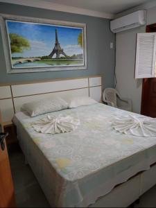 a bedroom with a bed with a picture of the eiffel tower at Village Taperapuan in Porto Seguro