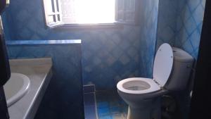 a bathroom with a toilet and a sink and a window at Soultana 2 pour les familles in Oualidia