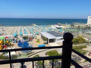 uma vista para uma praia com um parque infantil e para o oceano em Residence Roxy em Misano Adriatico