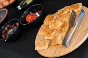 a cutting board with a knife and bread on a table at Centro Hotel Ioannina in Ioannina