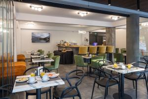 a restaurant with tables and chairs and a bar at Centro Hotel Ioannina in Ioannina