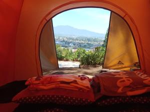 a bedroom with a window with a view of a city at Glamping ReaVeeCafe Puncak in Puncak