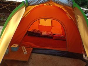 an orange and green tent with a bed in it at Glamping ReaVeeCafe Puncak in Puncak