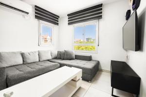 a living room with a couch and a tv at relaxing duplex in ashdod by torohome in Ashdod