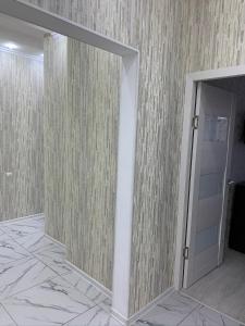 pasillo con espejo y puerta en la habitación en Кылышбай акына, en Taraz