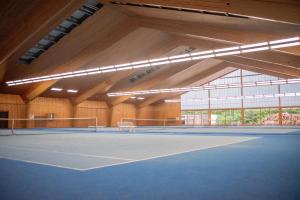 an indoor tennis court with lights on it at Hotel Restaurant Moosmühle in Dietenhofen