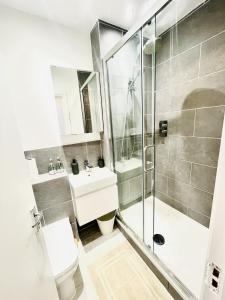 a bathroom with a shower and a toilet and a sink at Islington Town House in London