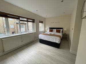 a bedroom with a large bed and two windows at Islington Town House in London