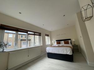 a bedroom with a large bed and two windows at Islington Town House in London