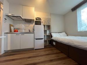 a small kitchen with a bed and a white refrigerator at Meguro-ku - House - Vacation STAY 8878 in Tokyo