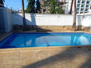a swimming pool with blue water in front of a building at Gia Apartment in Shanzu