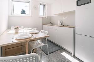 a kitchen with a wooden table and white appliances at Apartments by Pyramid: Christoph in Bratislava