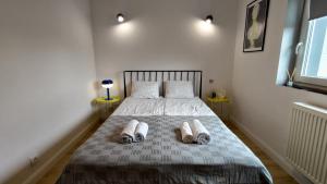 una camera con un letto e due paia di pantofole sopra di Konstancin Comfort - Twój Dom z Daleka od Domu a Konstancin-Jeziorna