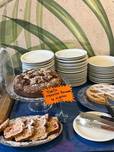 a table with several different types of cakes and pies at Hotel Lucerna in Castiglione della Pescaia