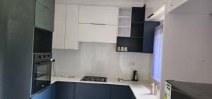 a kitchen with white cabinets and blue counters at Lovely 3 bed in Mount Pleasant - 2153 in Kingsmead