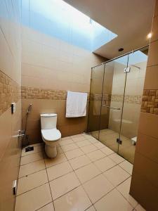 a bathroom with a toilet and a shower at Haven Lodge, 4BR Vacation Home with Park Access in Rāmkot +29 photos