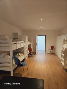 um quarto com beliches, uma secretária e cadeiras em Estelada Boarding Houses em Munique