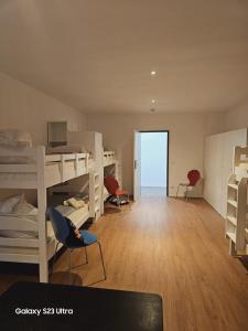 a room with bunk beds and a desk and chairs at Estelada Hostel Berg am Laim in Munich