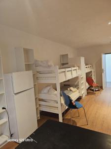 a room with two bunk beds and a refrigerator at Estelada Hostel Berg am Laim in Munich +18 photos