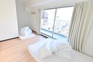 Un dormitorio con una cama y una ventana grande. en 東京 上野 稻荷町3分鐘130平方別墅 6LDK 3 Shower room Ueno Inaricho Private Villa, en Tokio