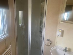 a bathroom with a shower and a sink at K&Ds Caravans in Chapel Saint Leonards
