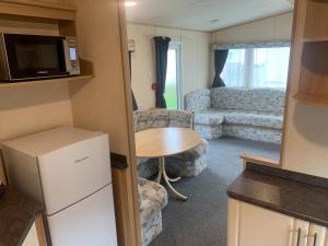 a small kitchen and living room in a caravan at K&Ds Caravans in Chapel Saint Leonards