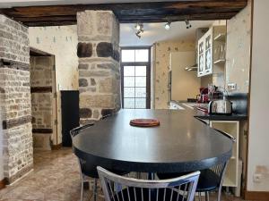 a kitchen with a large black table and chairs at Le temps de vivre in Saint-Seine-lʼAbbaye