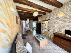a living room with a couch and a brick wall at Le temps de vivre in Saint-Seine-lʼAbbaye