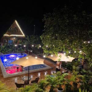 una piscina al aire libre por la noche con sombrilla en Tinipak Lodge, en Tanay