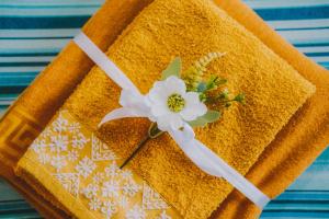 a yellow towel with a white flower on it at B&b Trebenoro in Lotzorai