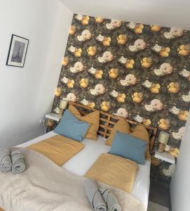 a bedroom with two beds and a floral wall at Gyöngy Apartman in Sopron