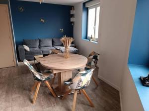 een woonkamer met een tafel en stoelen en een bank bij Charmante maison tout confort 