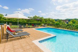 - une piscine avec un parasol et une chaise dans l'établissement La Barde Montfort, votre maison d'hôtes à 4 kms de Sarlat Dordogne, à Vitrac