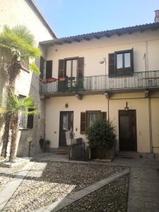 a house with a balcony and a palm tree at Residenza Esse in Angera