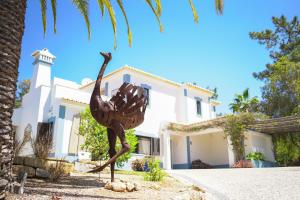 Una statua di un uccello davanti a una casa di Quinta do Rosal a Carvoeiro