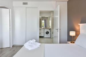 a white bedroom with a bed and a washing machine at OVELIA Toulouse - Les Bastides de Lardenne in Toulouse