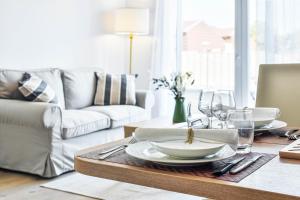 a living room with a table with plates and wine glasses at OVELIA Toulouse - Les Bastides de Lardenne in Toulouse