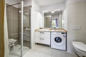 a bathroom with a washing machine and a shower at OVELIA Toulouse - Les Bastides de Lardenne in Toulouse