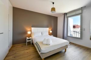 a bedroom with a bed with two towels on it at OVELIA Toulouse - Les Bastides de Lardenne in Toulouse