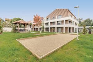 a large house with a volleyball court in front of it at OVELIA Toulouse - Les Bastides de Lardenne in Toulouse