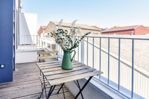 a vase of flowers sitting on a table on a balcony at OVELIA Toulouse - Les Bastides de Lardenne in Toulouse