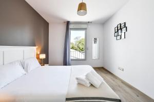 a white bedroom with a large bed and a window at OVELIA Toulouse - Les Bastides de Lardenne in Toulouse