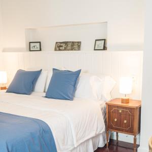 a bedroom with a bed with blue pillows and a night stand at Bella Tilcara Boutique Hotel in Tilcara